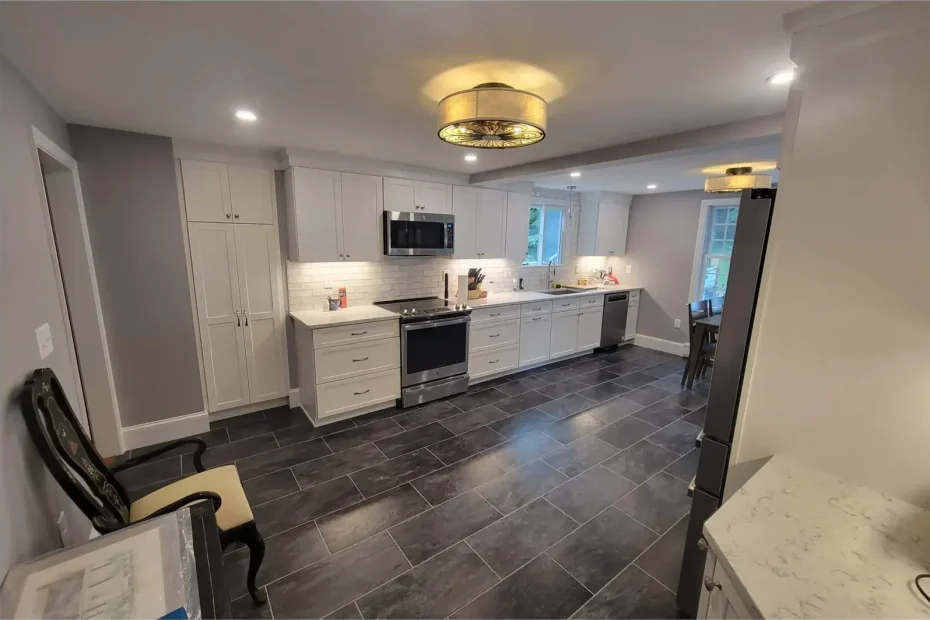 Finished kitchen: white shaker cabinets, stainless appliances, subway tile backsplash, dark grey tile floor