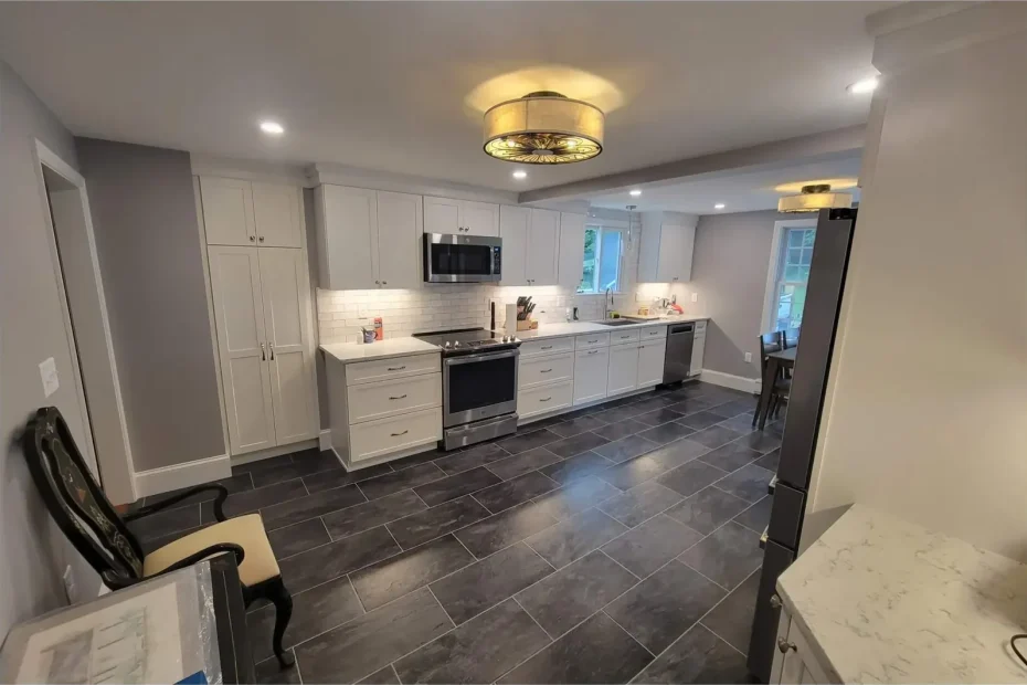 Finished kitchen with white cabinets, subway backsplash, stainless appliances and dark grey tile floor